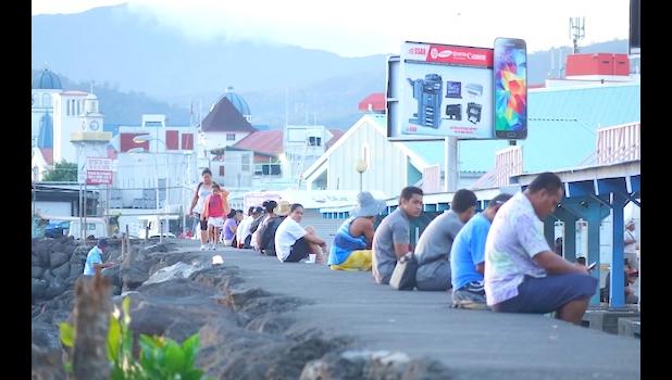 Apia residents sitting on the sea wall