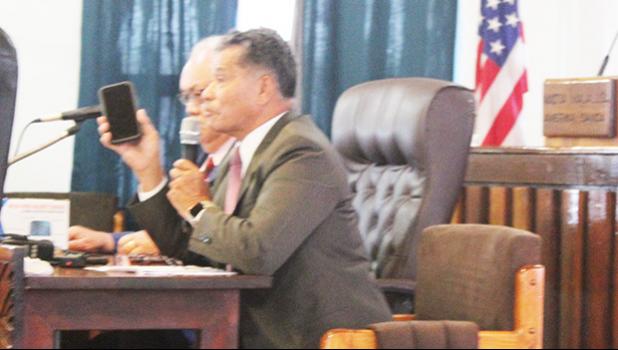 Homeland Security director Samana Semo Ve’ave’a holds up an iPhone