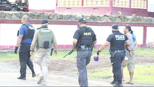 Police officers leading a suspect away 