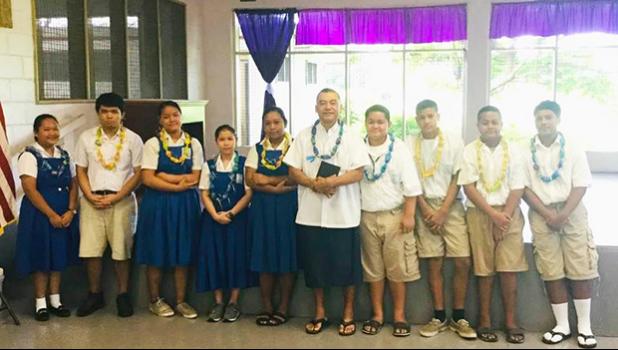 Rev. Father Kolio Etuale (middle) surrounded by students of St. Theresa Elementary School