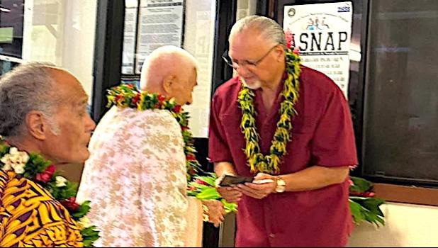 Mrs. Pisa Tauai receives the first card from the governor