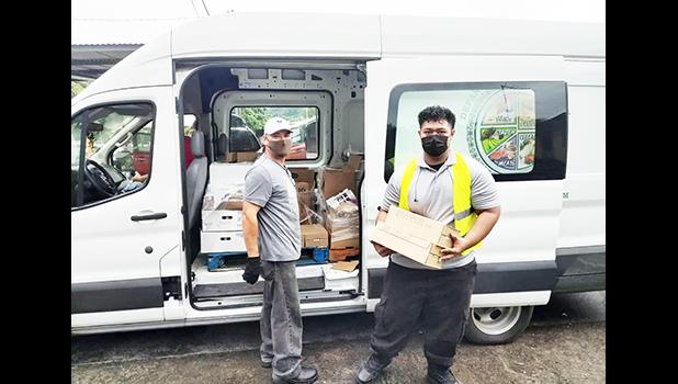 Two men and truck with food for delivery