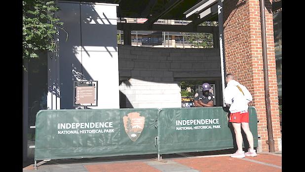 A man looks on in front of a barrier as Liberty Bell Center is closed due to a government shutdown, in Philadelphia, Wednesday, Oct. 1, 2025. (AP Photo/Matt Rourke) federal government shutdown