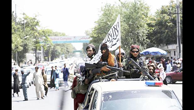 Taliban fighters display their flag while on patrol in Kabul, Afghanistan, Thursday, Aug. 19, 2021. The Taliban celebrated Afghanistan's Independence Day on Thursday by declaring they beat the United States, but challenges to their rule ranging from running a country severely short on cash and bureaucrats to potentially facing an armed opposition began to emerge. (AP Photo/Rahmat Gul)