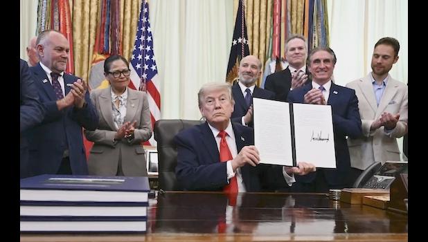 US President Donald Trump displays a proclamation 