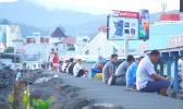 Apia residents sitting on the sea wall